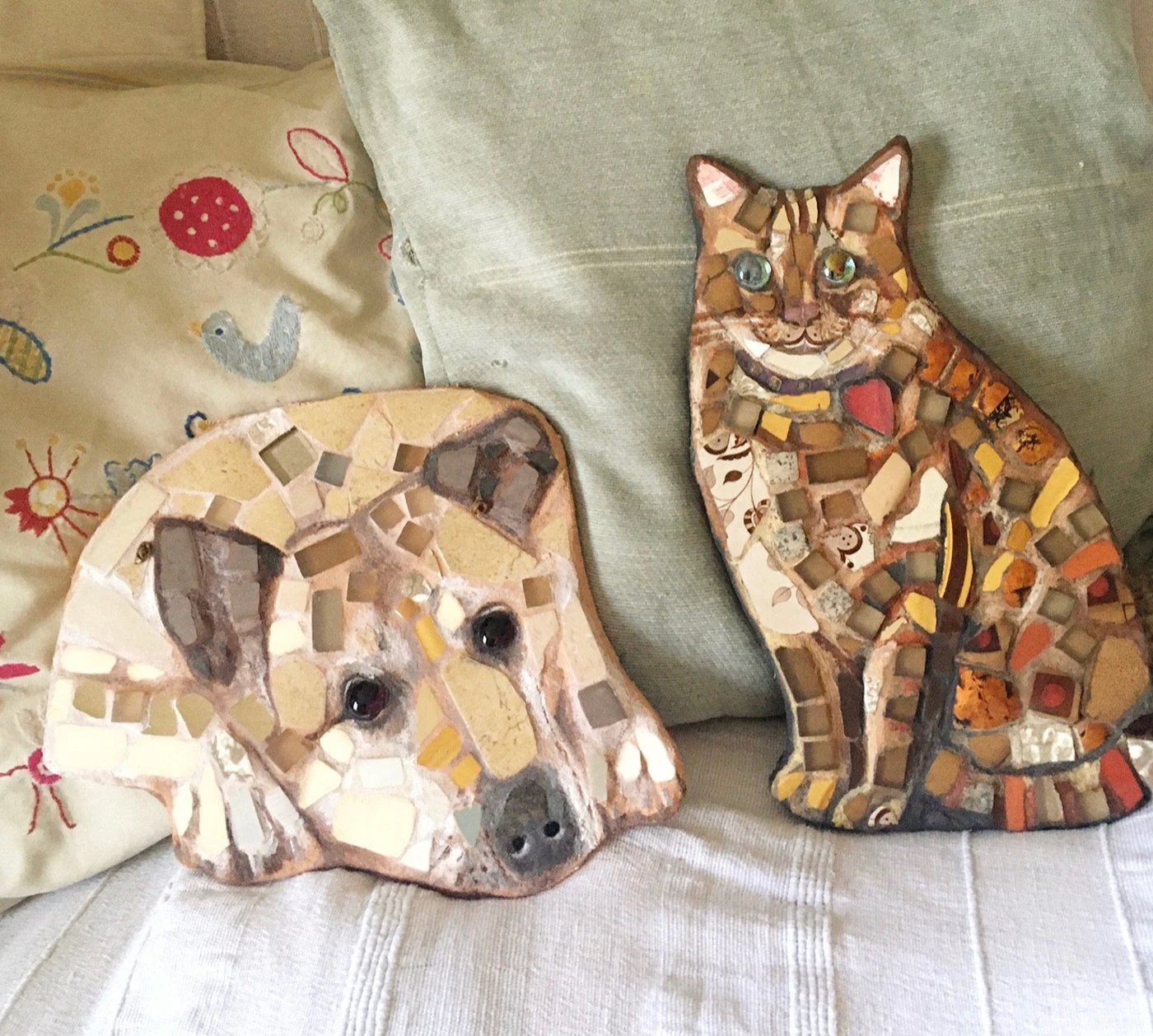 Pair of mosaic portraits, a dog and a cat, in warm earth tones