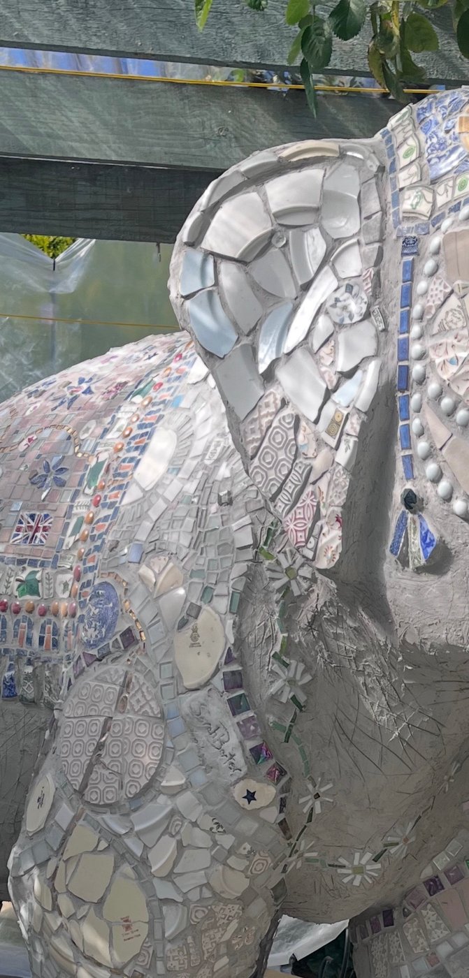 Close-up detail of Quiet Majesty, a mosaic elephant, showing the intricate vintage ceramic and mirror work across the ear and body
