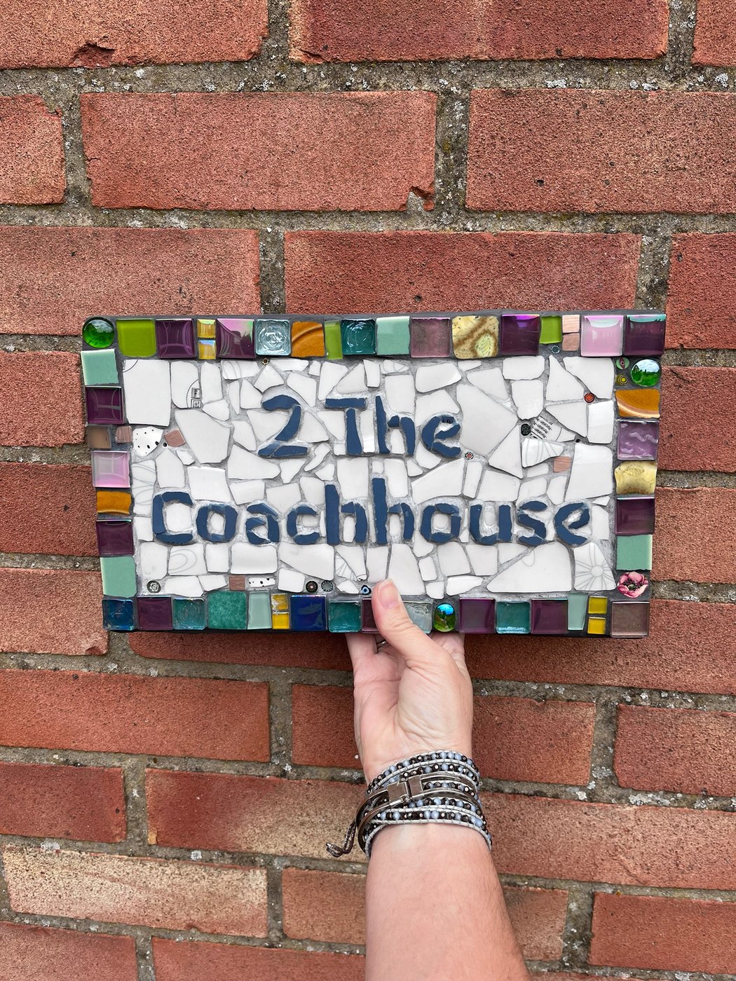 Mosaic house number plaque reading '2 The Coachhouse' in blue lettering
